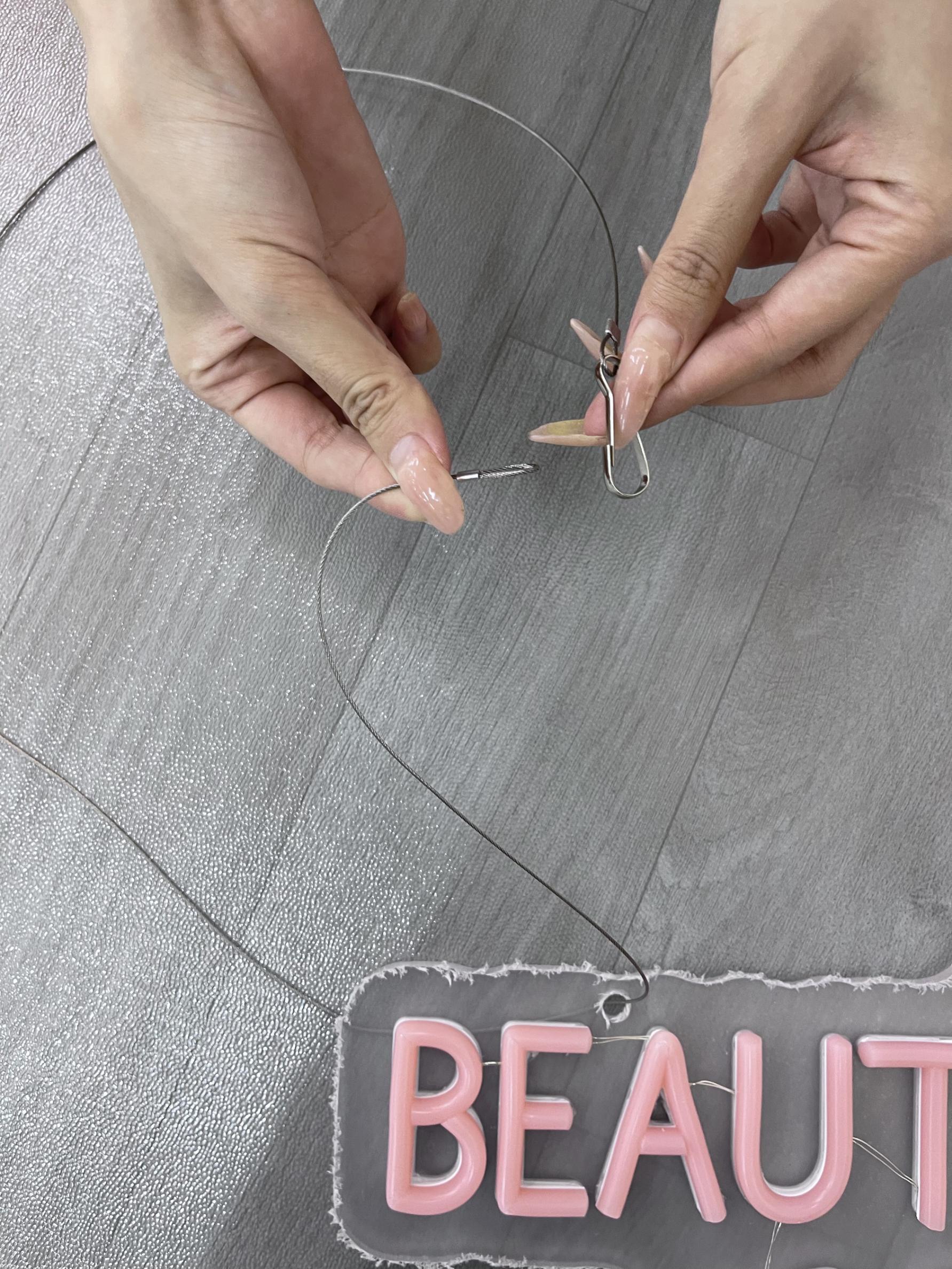 Putting the hanging chain into the neon sign hole